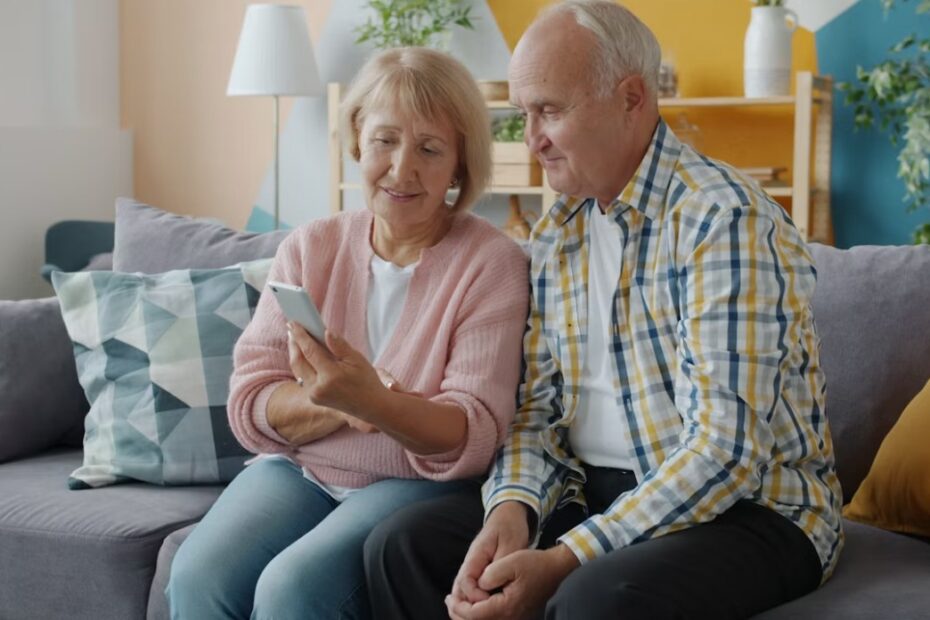 Älteres Paar, das zusammen auf der Couch auf ein Smartphone schaut